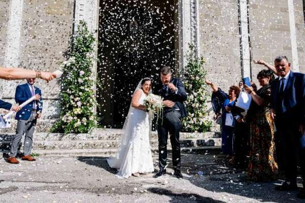 coppia di sposi sotto una pioggia di confetti